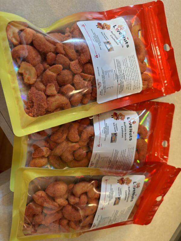 Three bags of nuts are lined up on a table.